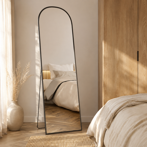 Arched black freestanding full-length mirror in a neutral bedroom
