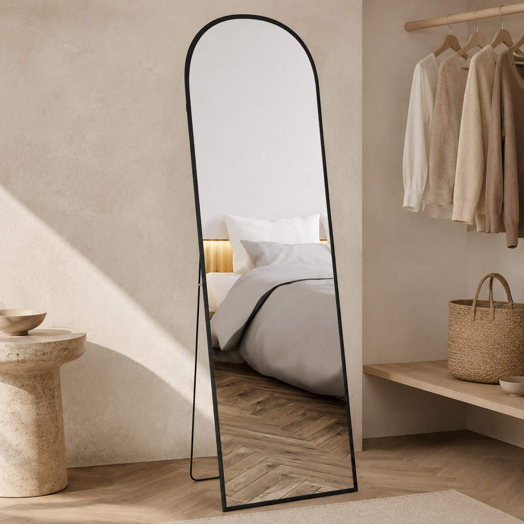 Black arched full-length mirror in a warm dressing room