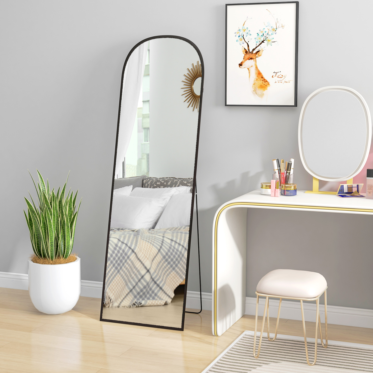 Arched black full-length mirror styled in a bedroom dressing area