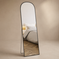 Arched black full-length mirror with slim freestanding support