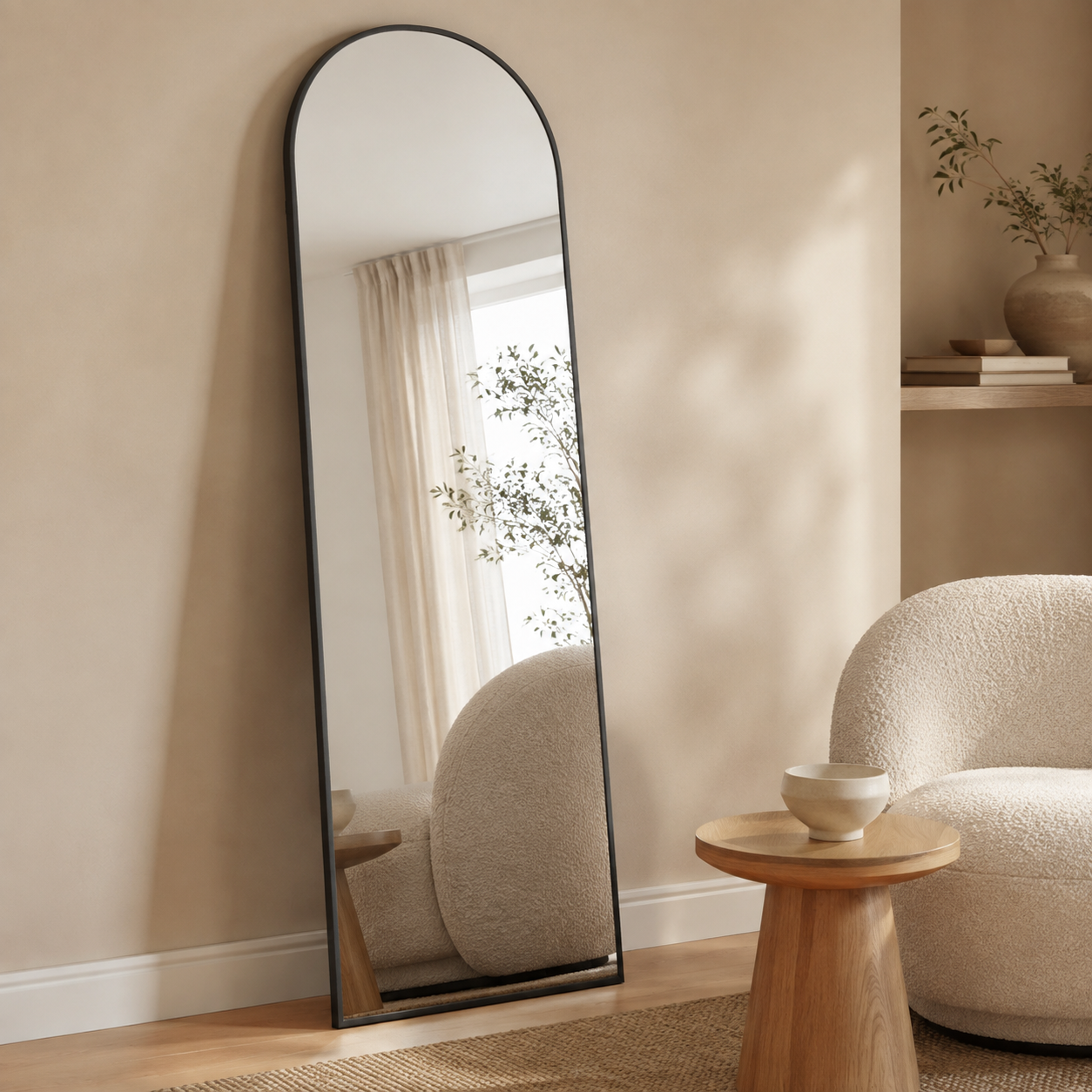 Black arched full-length mirror leaning in a neutral living room