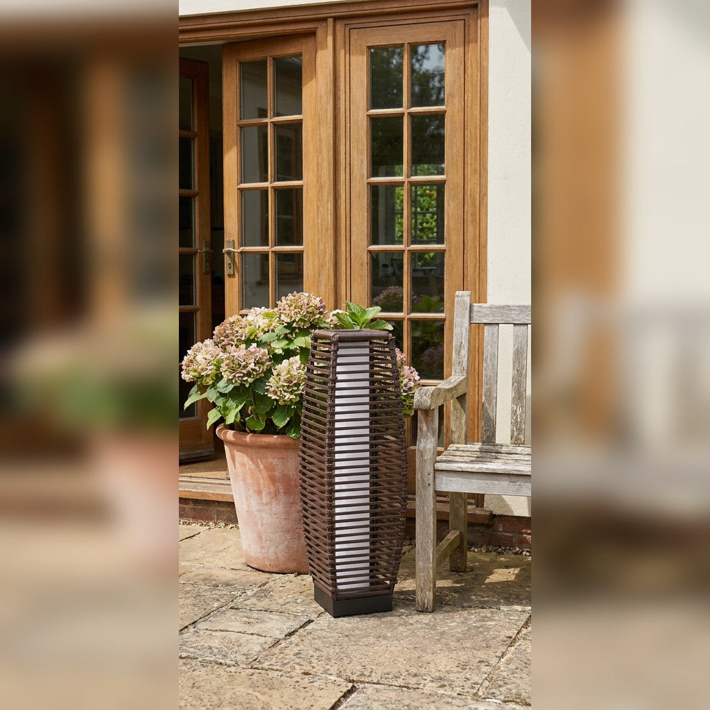 Brown rattan-effect solar floor lamp beside patio doors and garden bench