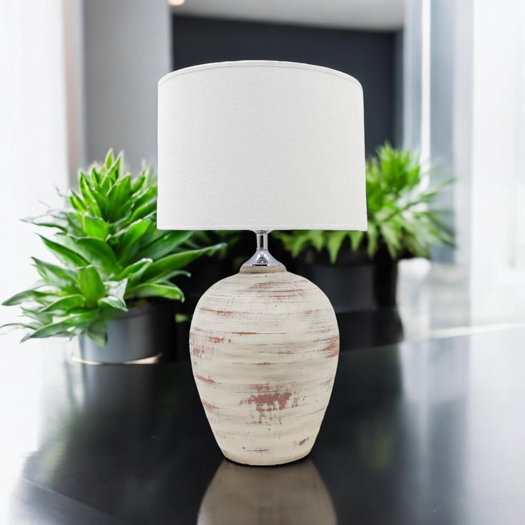 Cream ceramic table lamp styled with indoor greenery