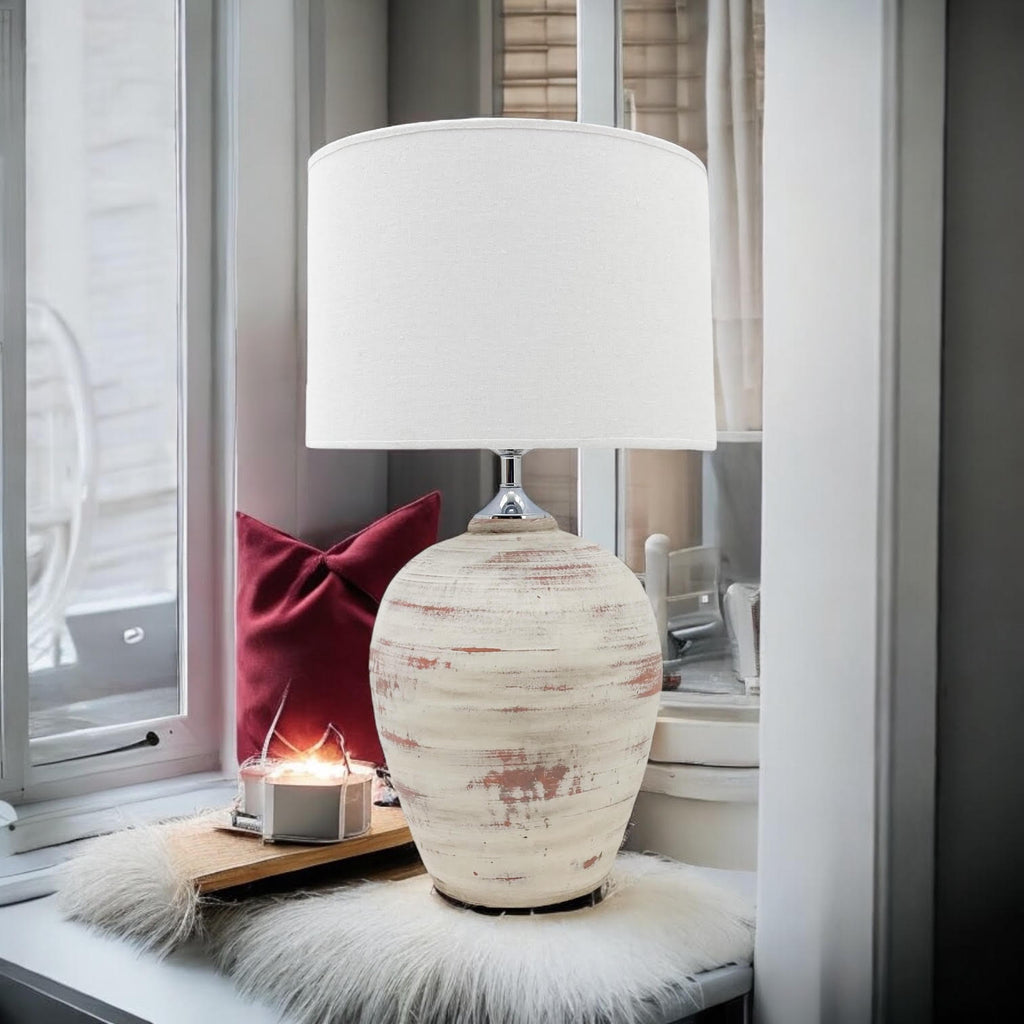 Rustic cream ceramic table lamp styled by a window seat