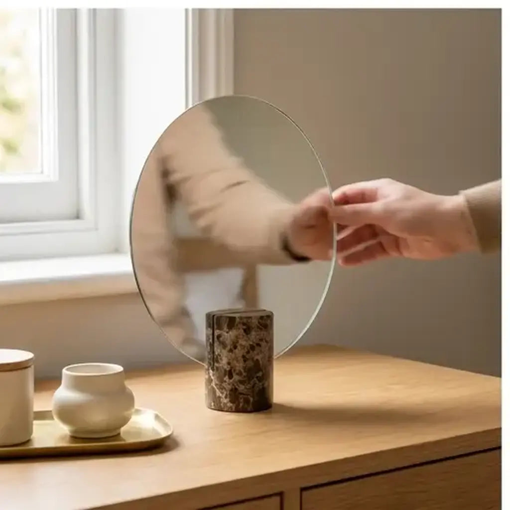 Freestanding vanity mirror with marble-effect base from a customer-friendly angle in a bedroom
