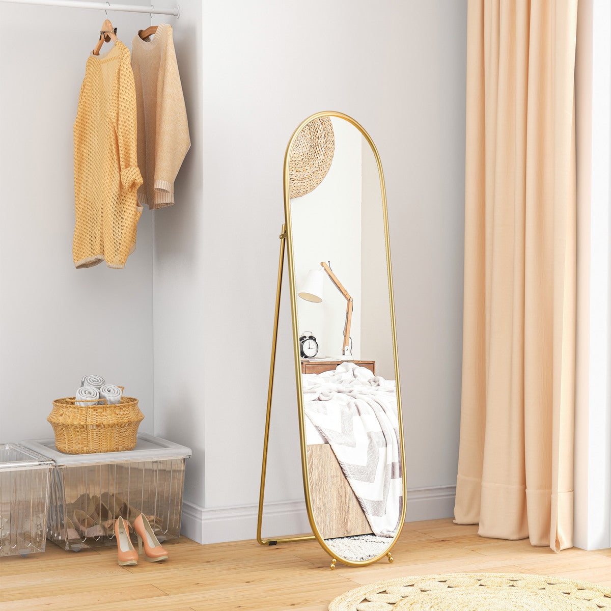 Gold oval full-length mirror styled in a dressing area