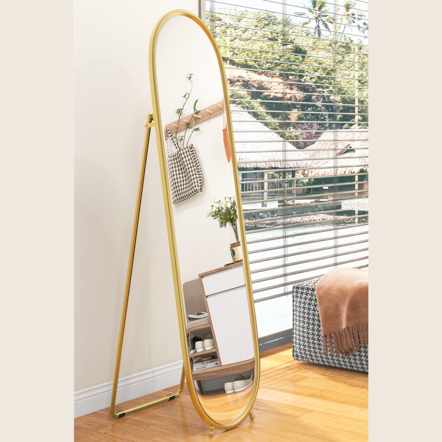 Gold oval mirror used freestanding with its support frame