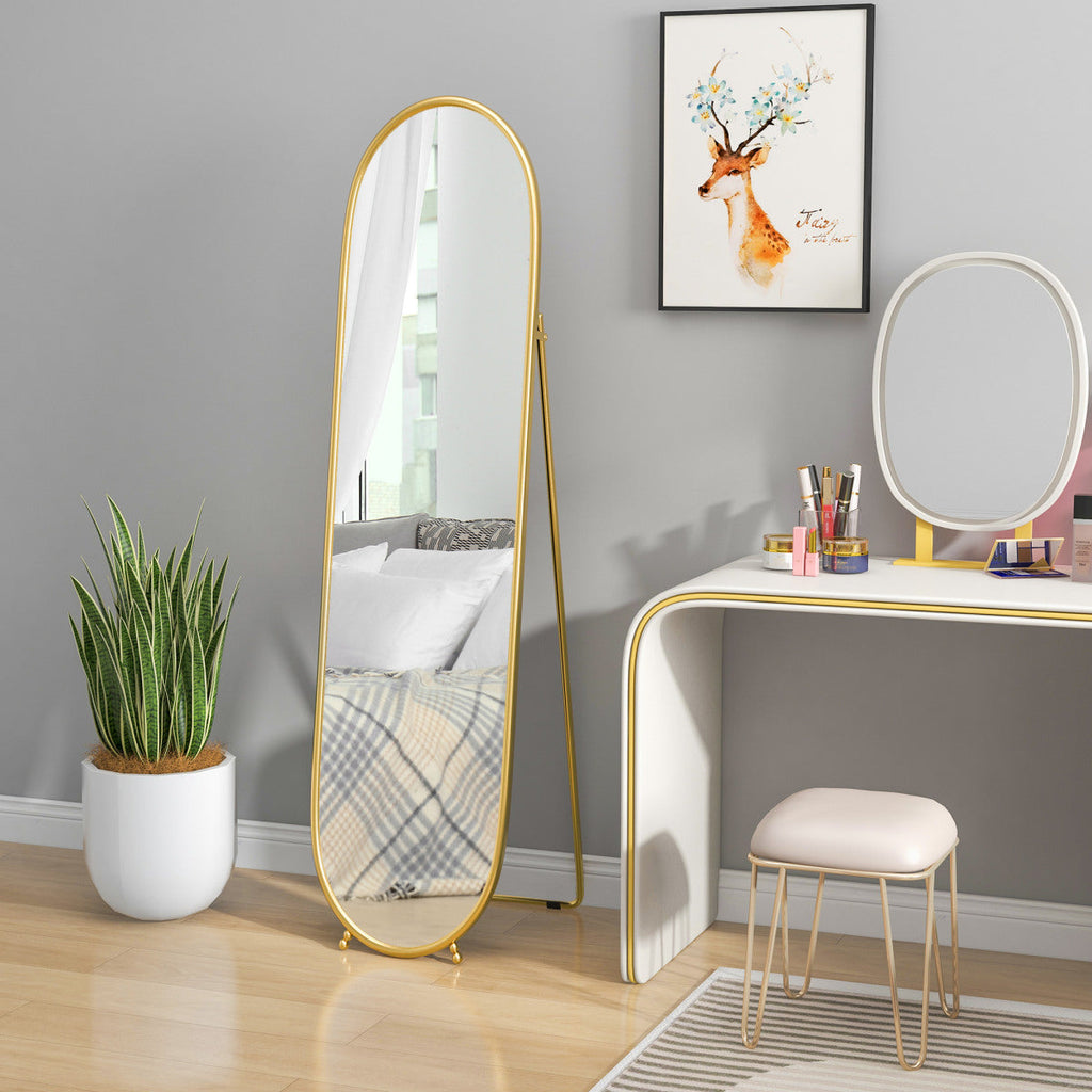 Gold oval full-length mirror beside a coordinating vanity