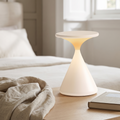 Cordless hourglass table lamp on a bedside table in a calm bedroom