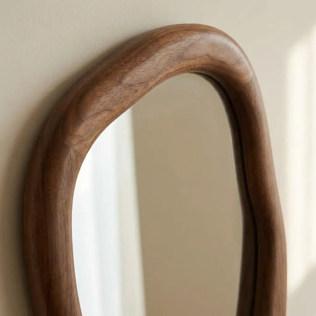 Irregular walnut wall mirror measuring 50 by 70cm with warm natural wood styling in a hallway