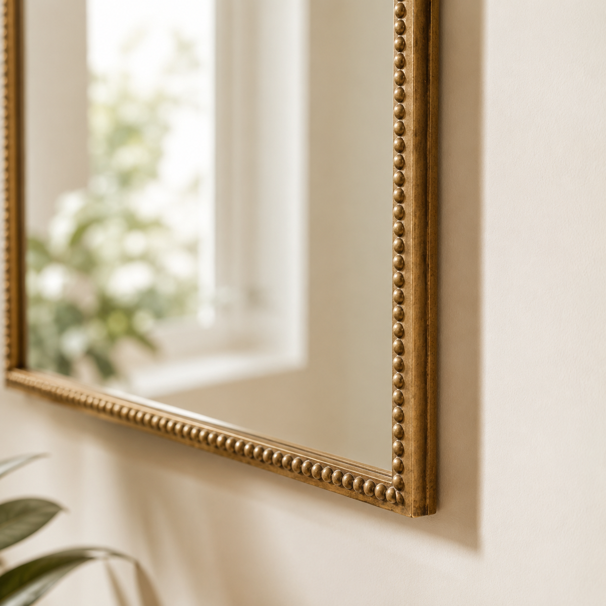 Distressed gold wall mirror with decorative beaded iron frame detail
