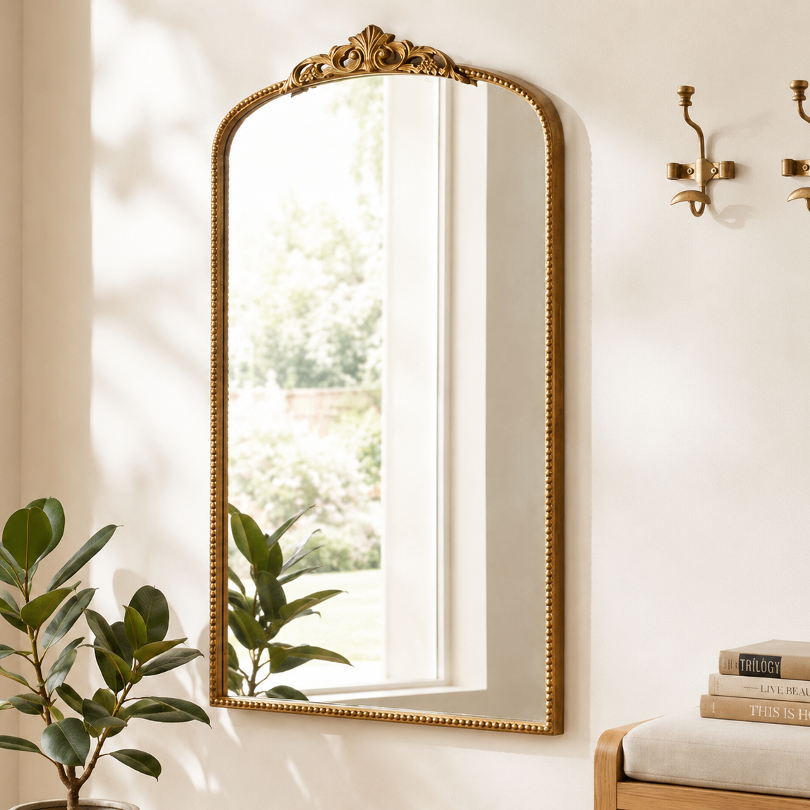 Ornate gold arch wall mirror showing carved botanical crest detail