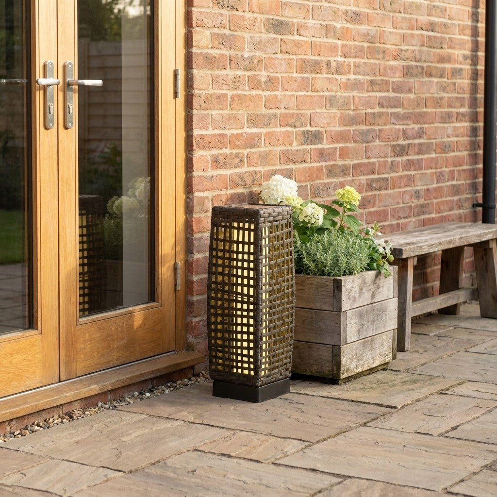 Outdoor solar garden lantern beside patio doors and planter