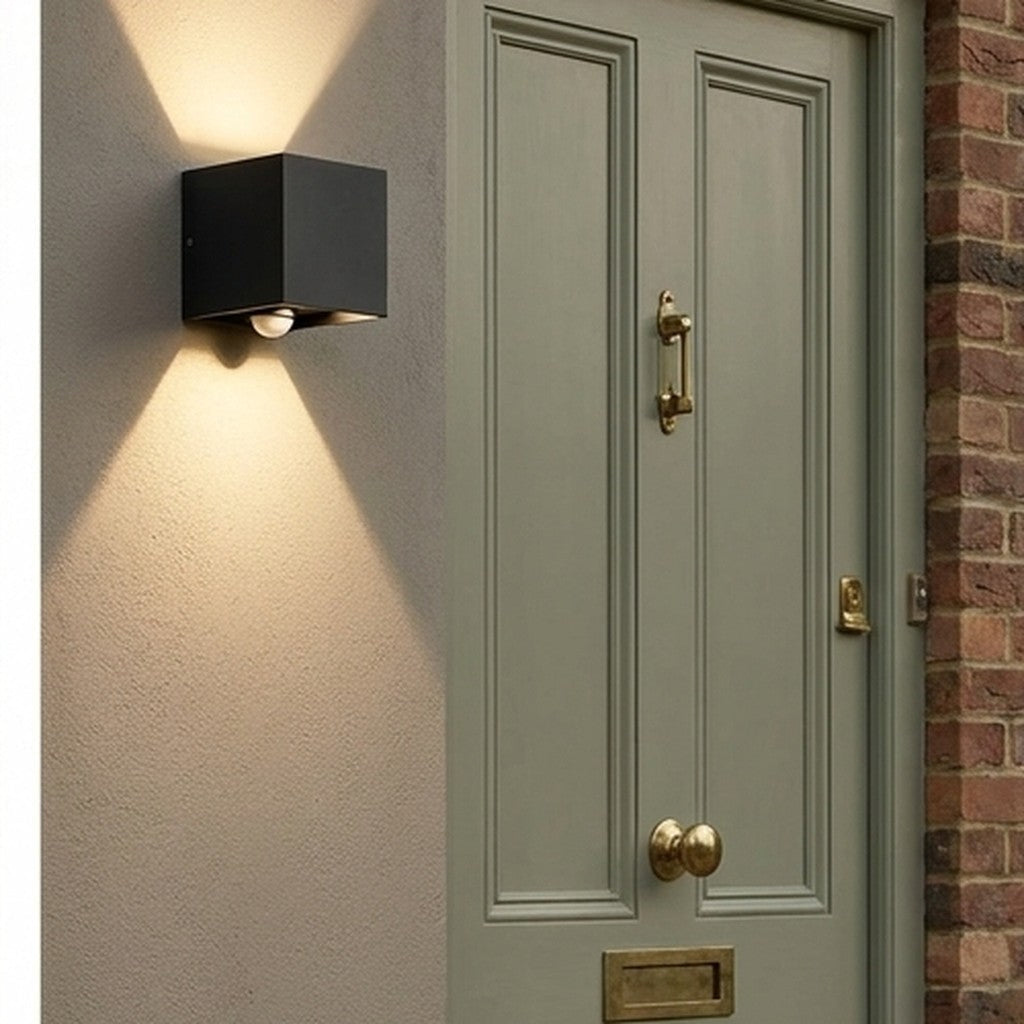 Modern outdoor wall light beside a painted front door and planter