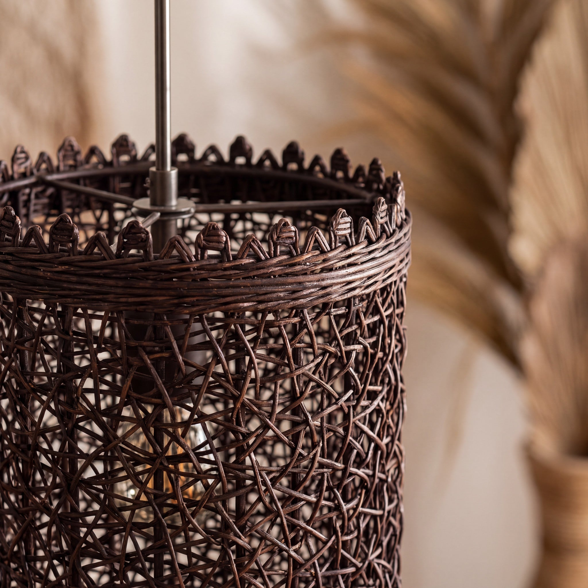 Close-up of the natural woven shade on a dark rattan pendant light