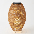 Rattan solar lantern with cut-out pattern on a white background