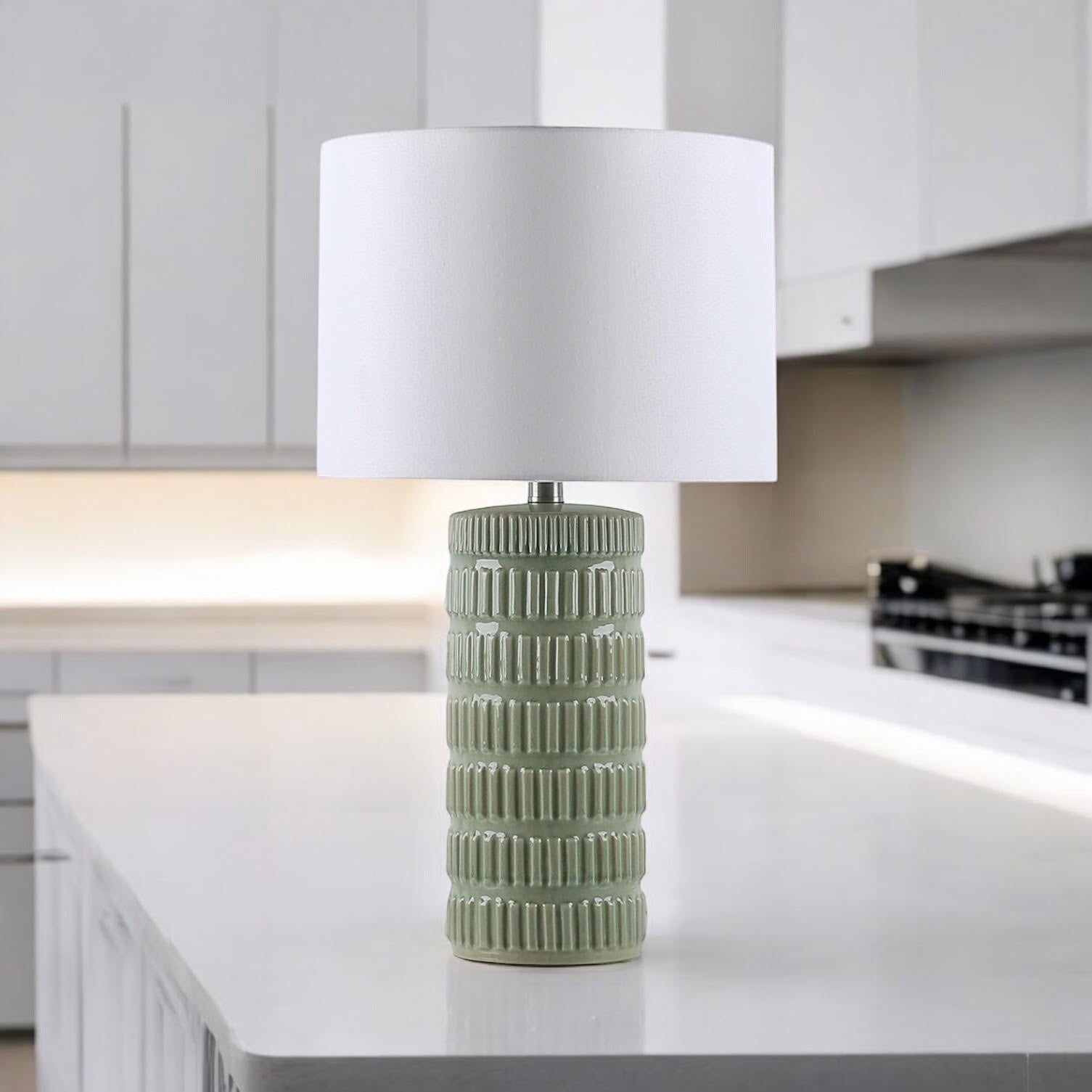 Sage green ceramic table lamp on a bright kitchen island