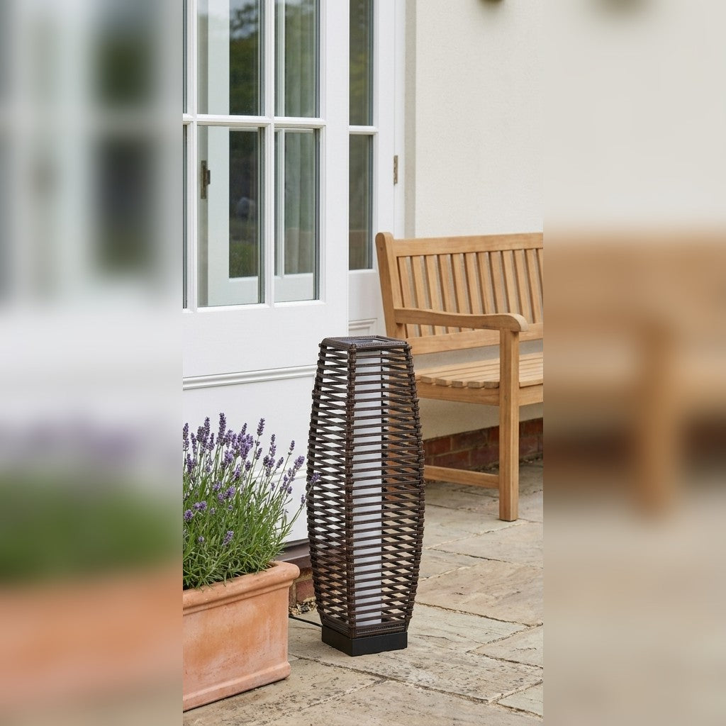 Rattan-effect solar floor lamp on a patio beside a wooden bench