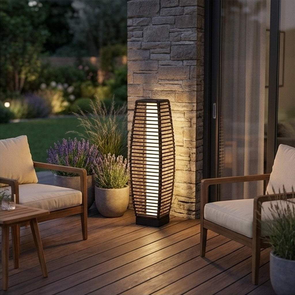 Solar floor lamp glowing beside outdoor patio seating at dusk