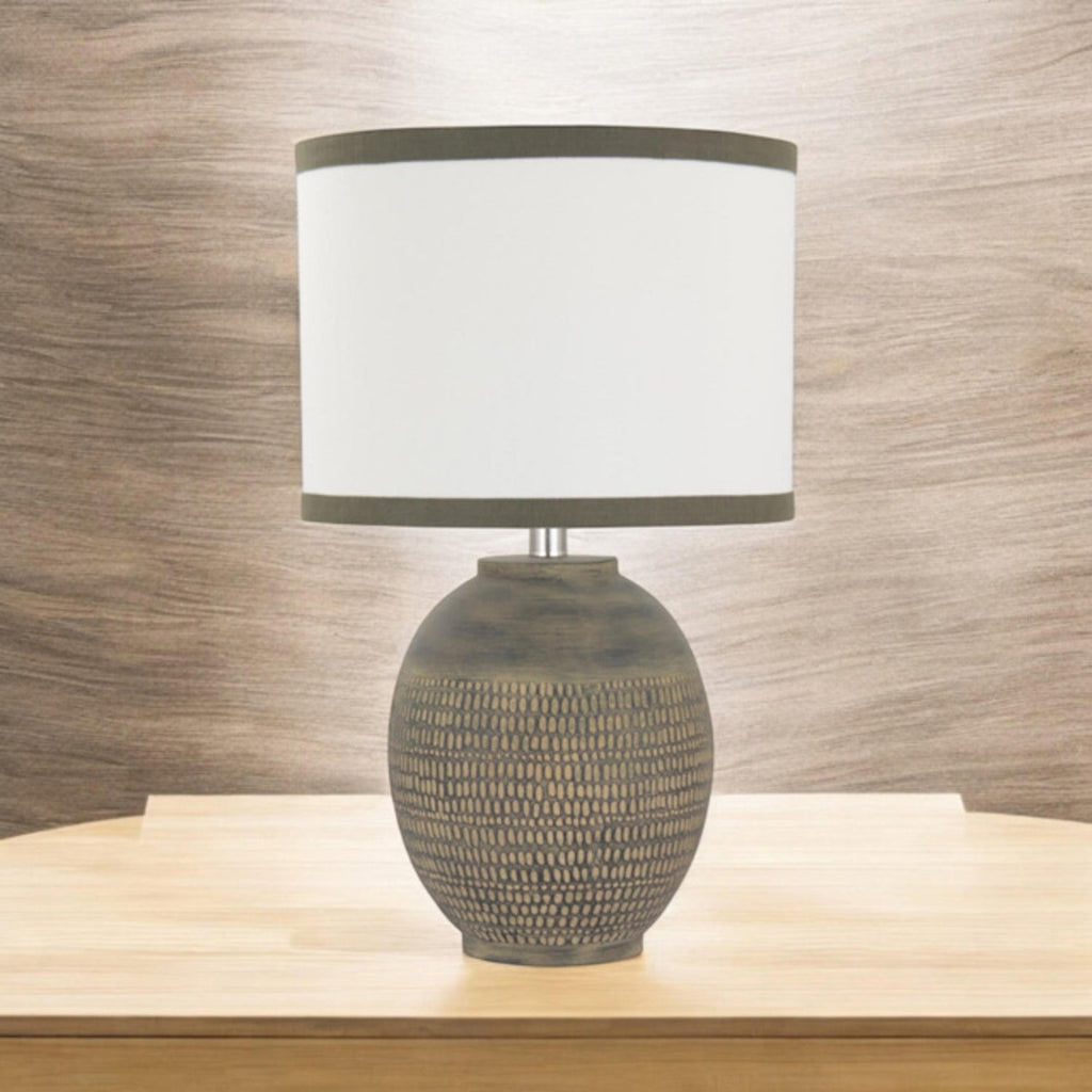 Textured beige ceramic table lamp on a pale wood console