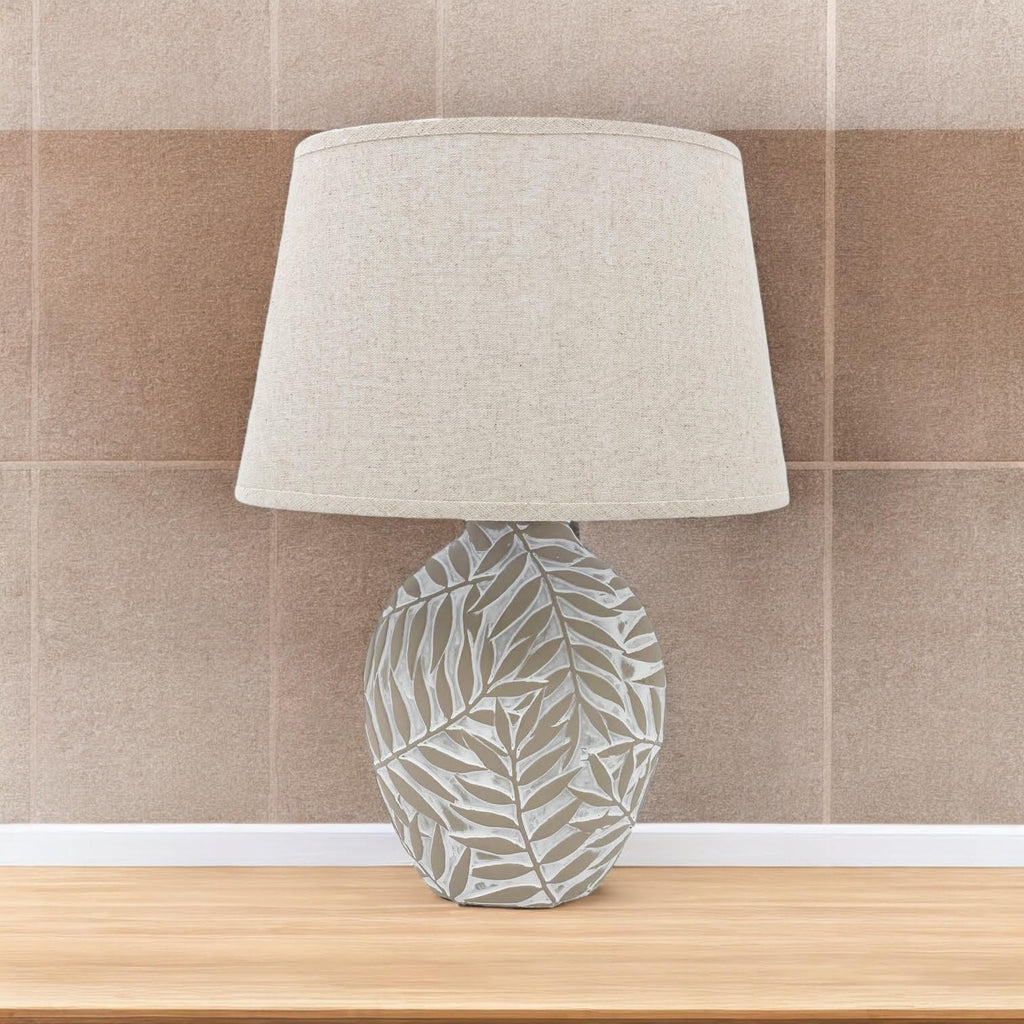 Leaf-pattern ceramic table lamp styled with green plants