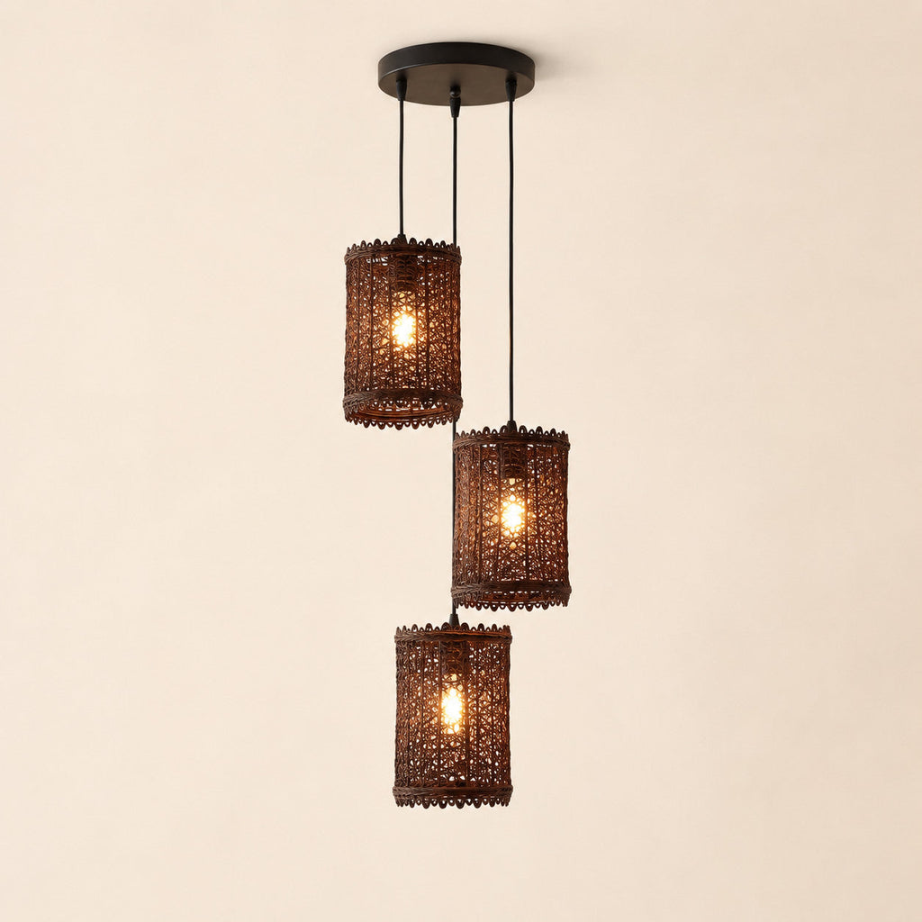 Three-light rattan pendant with round black base and woven shades on a warm cream Nestria background