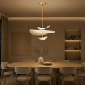 Warm sculptural LED pendant light illuminating a neutral evening dining room